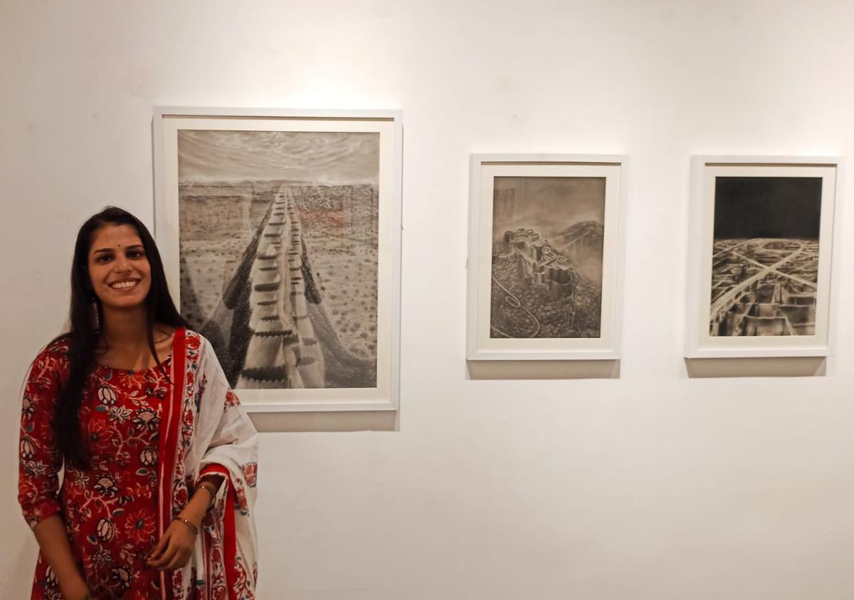 Deepa Kumawat with her paintings done in charcoal