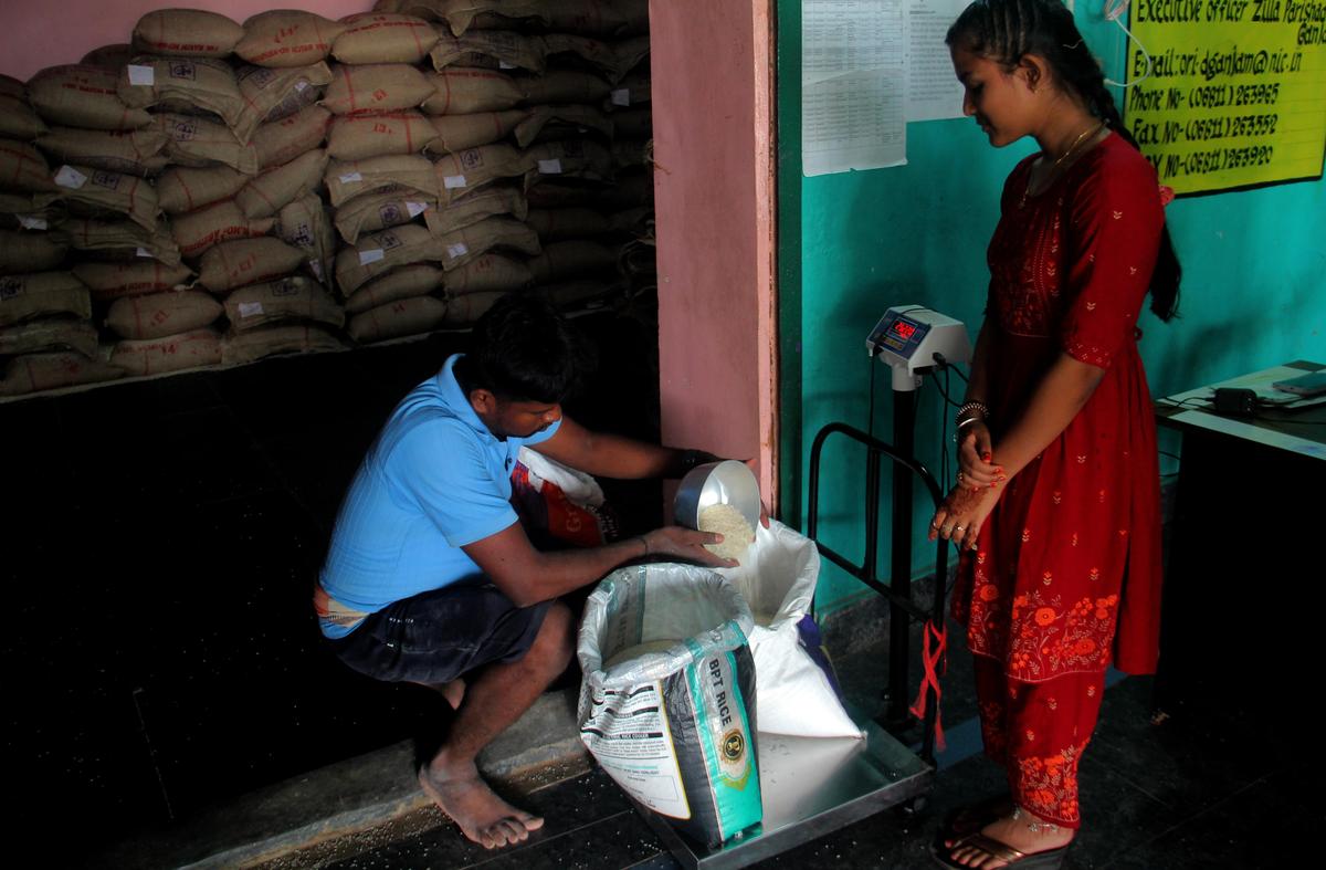A girl is seen at her panchayat office collecting ration for her family, as her parents are working in the Gulf region at Manikapur in Ganjam district, Odisha.