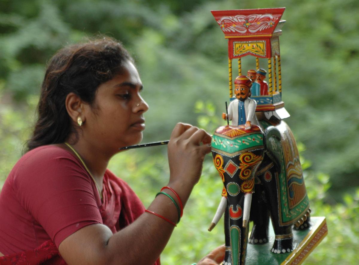 An artisan painting a Kondapalli toy An artisan painting a Kondapalli toy