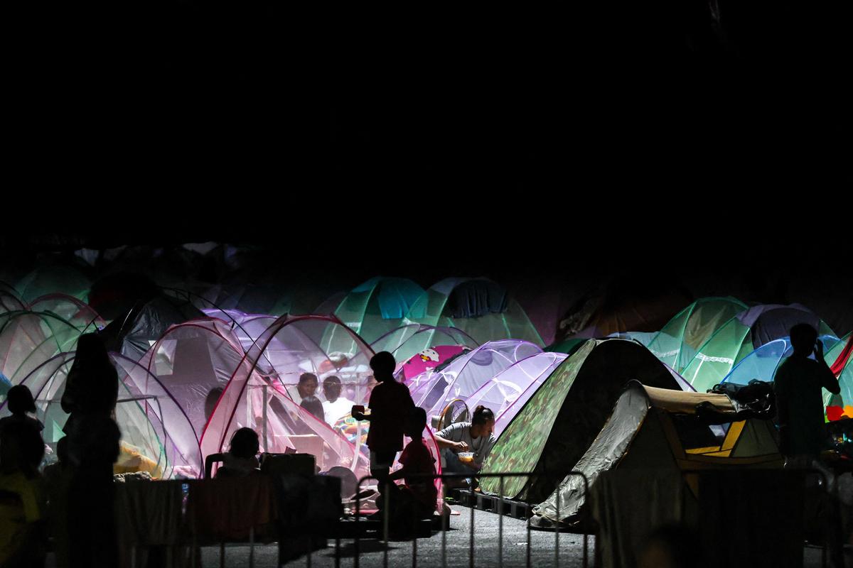 Displaced people gather inside a temporary shelter amid clashes between Thailand and Cambodia along a disputed border area, in Buriram Province, Thailand, on December 16, 2025. 