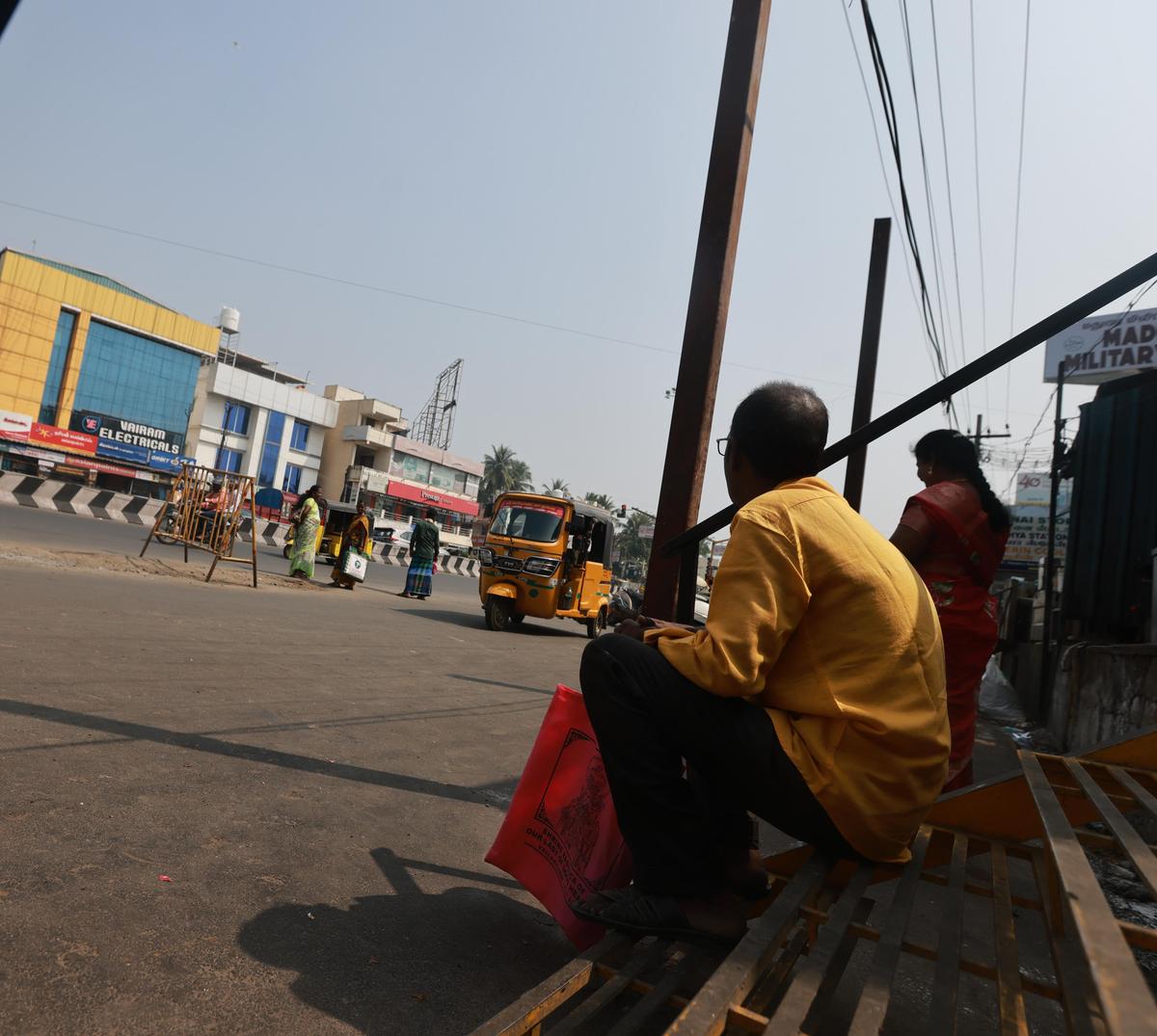 At the Mahalakshmi Nagar bus stop on Tambaram Velachery Main Road, commuters resort to finding seating spaces at commercial establishments nearby