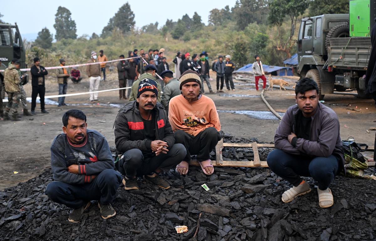 Relatives wait for bodies to be brought out at the disaster site.