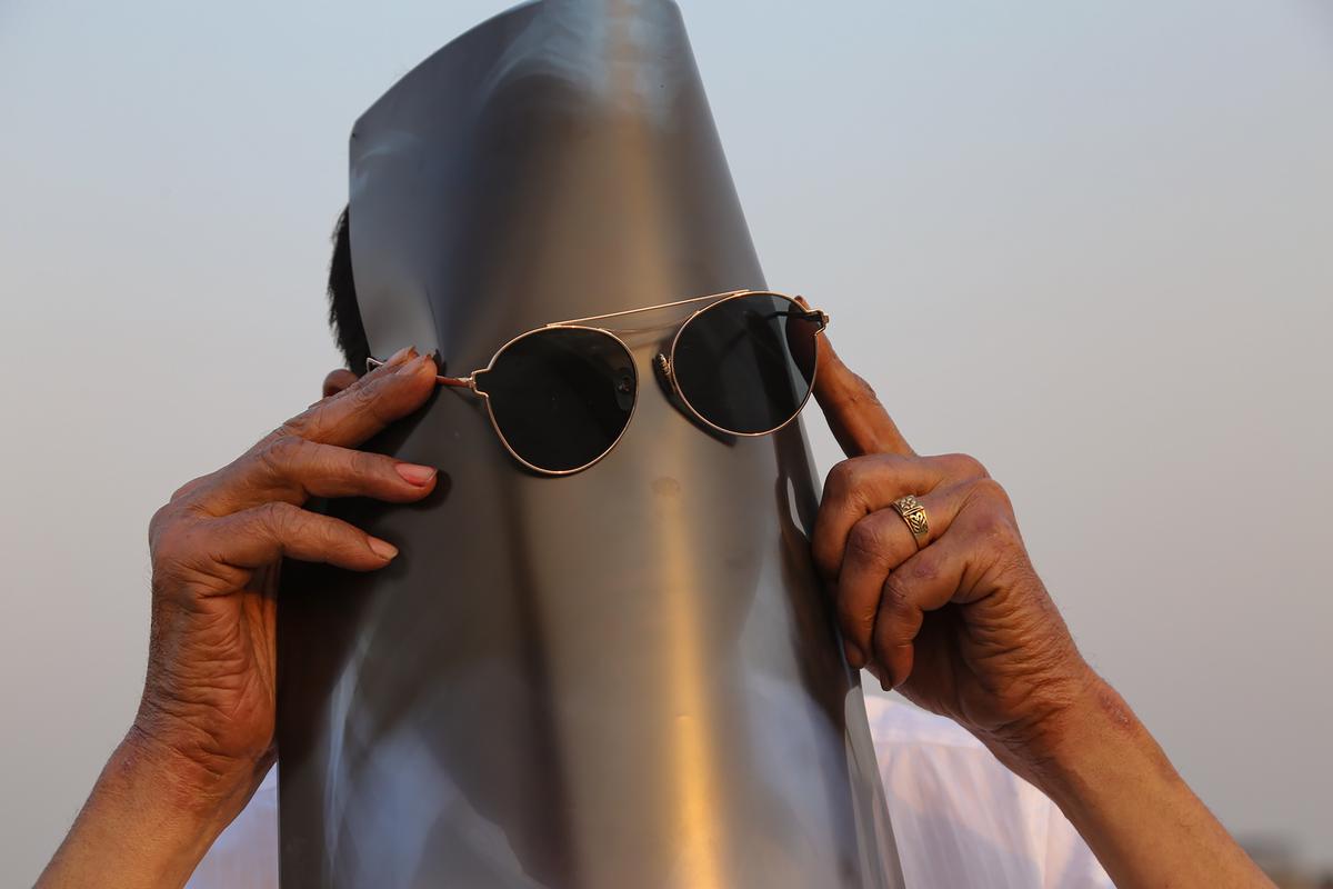 Mathura: A man watches the solar eclipse through a strip of exposed x-ray film and a sunglass in Mathura on Tuesday,