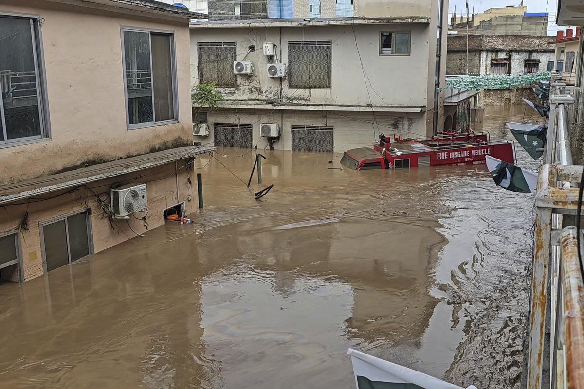 A firefighting department vehicle submerged in a floodwater following flash flooding due to heavy rains in the neighbourhood of Mingora, the main town of Swat Valley, northwestern Pakistan, on August 15, 2025. 