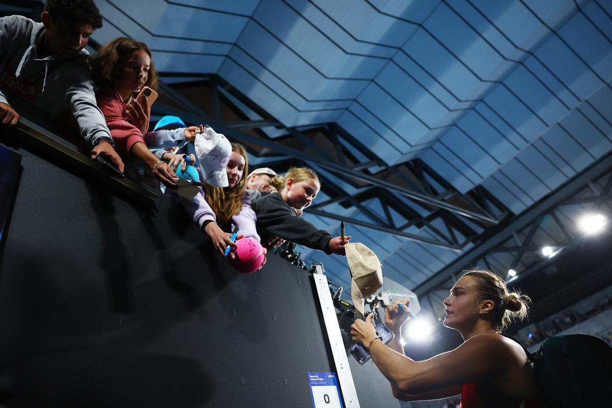 Belarus’ Aryna Sabalenka signs autographs for fans after winning her fourth-round match against Amanda Anisimova of the U.S. in the Australian Open on Jan. 21