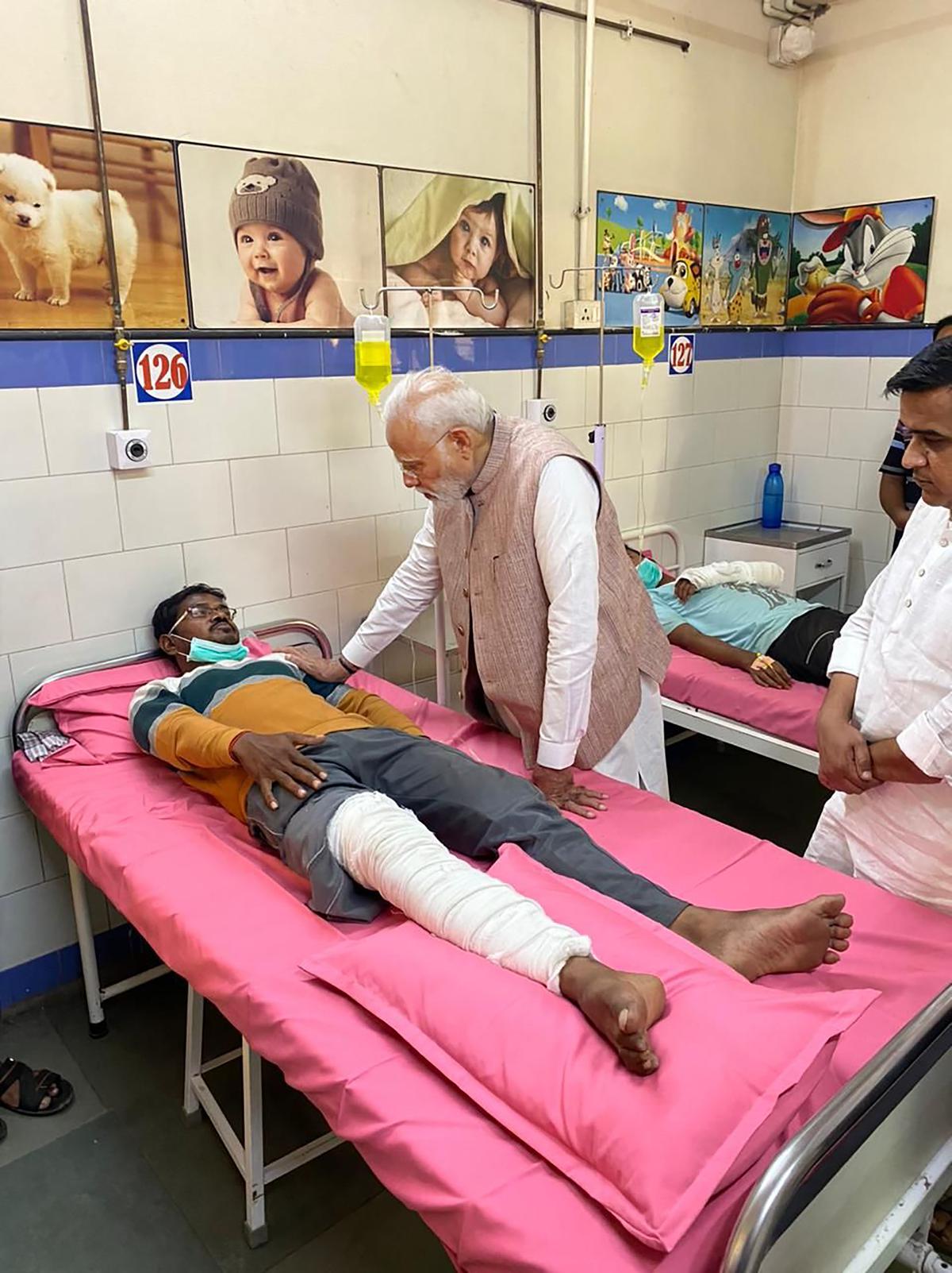 Prime Minister Narendra Modi meets a victim injured in a bridge collapse at the Civil Hospital in Morbi district on November 1, 2022.