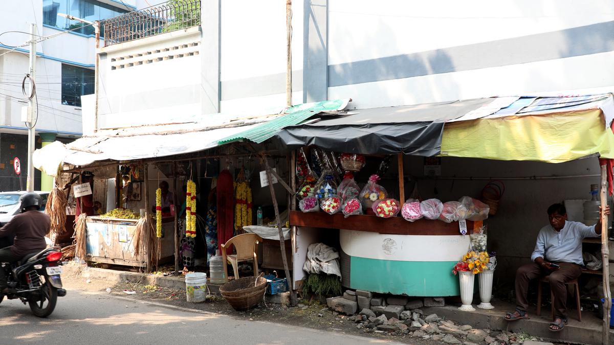 A street struggles with unauthorised parking, shops, and inundation