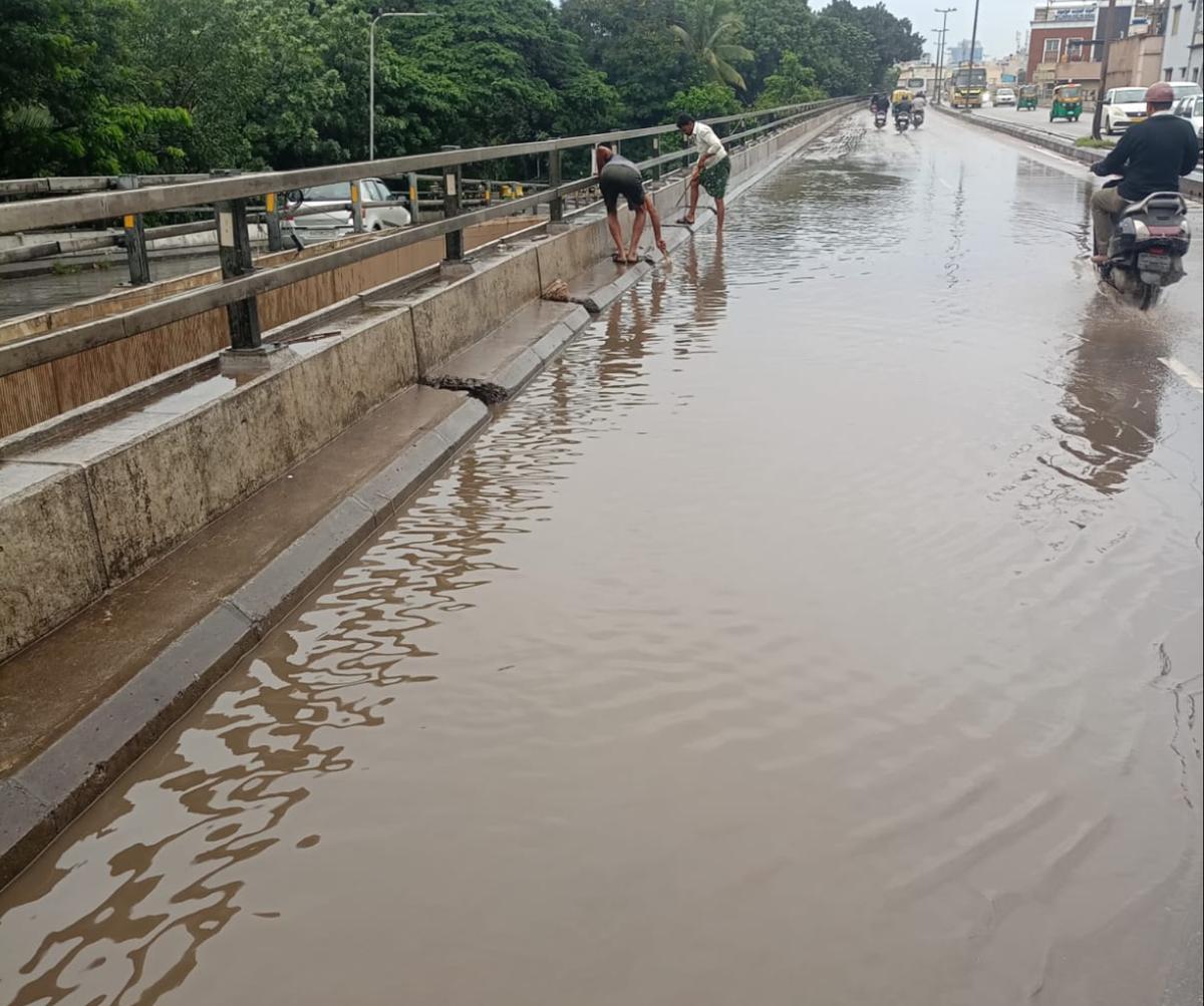 BBMP workers clearing flooded Mysuru road flyover in Bengaluru. 