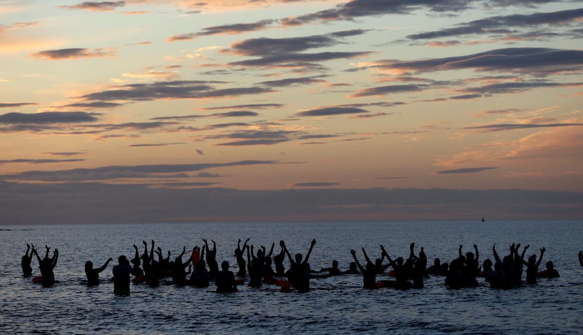 Members of Wild Sea Women take part in a Wild Kundalini Yoga class during sunrise in Seaburn, Britain, on June 21, 2022.