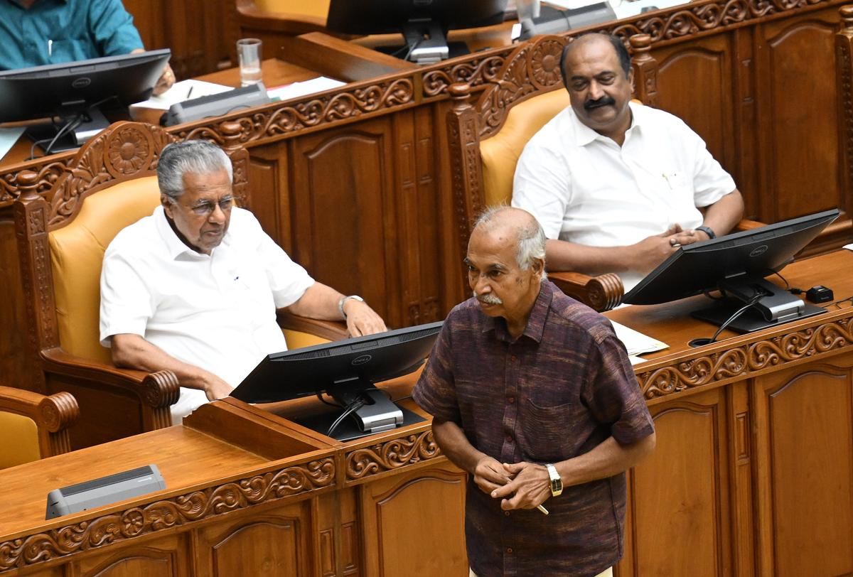 Payyannur MLA V. Kunhikrishnan passa pelo líder da oposição Pinarayi Vijayan na Assembleia do Estado em Thiruvananthapuram na quinta-feira.