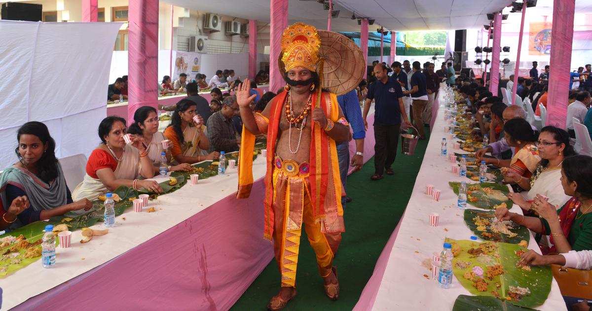 A man dressed as King Mahabali seen greeting people enjoying the Onam Sadhya, a traditional feast on a banana leaf on Onam at the Kerala House in New Delhi.  file photo