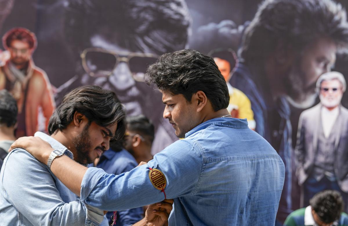 A fan of superstar Rajinikanth ties an armband to another while celebrating the release of the actor’s new film ‘Coolie’, outside a movie theatre in Chennai, Thursday, Aug. 14, 2025 A fan of superstar Rajinikanth ties an armband to another while celebrating the release of the actor’s new film ‘Coolie’, outside a movie theatre in Chennai, Thursday, Aug. 14, 2025