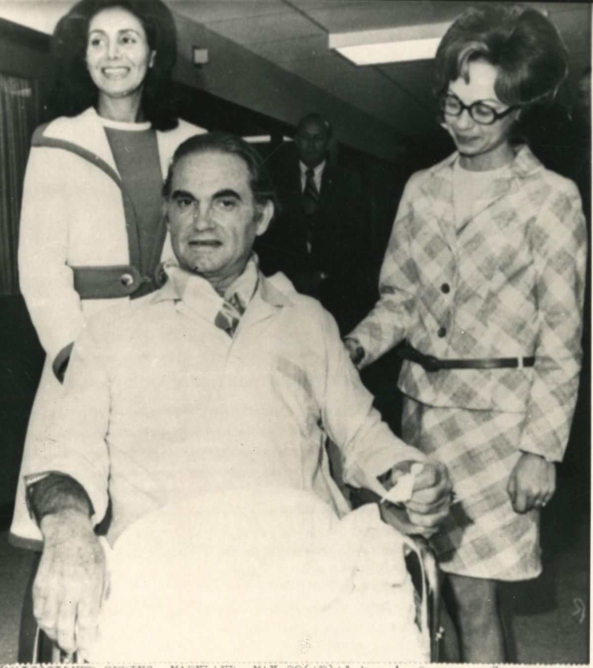 Alabama’s Governor George Wallace seated in wheel chair is pushed through the hallway of Holy Cross Hospital by his wife Cornelia (left) and daughter Mrs. Bobby Jo Parsons on May 28, 1972 in Silver Spring, Maryland. 