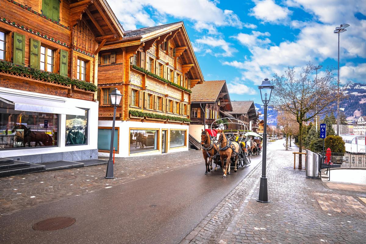 A horse carriage runsthrough the village of Gstaad in Switzerland A horse carriage runsthrough the village of Gstaad in Switzerland