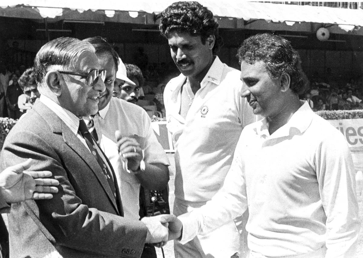 S.L. Khurana, Governor of Tamil Nadu greets Sunil Gavaskar on the eve of 100th cricket Test match as Kapil Dev looks on. 