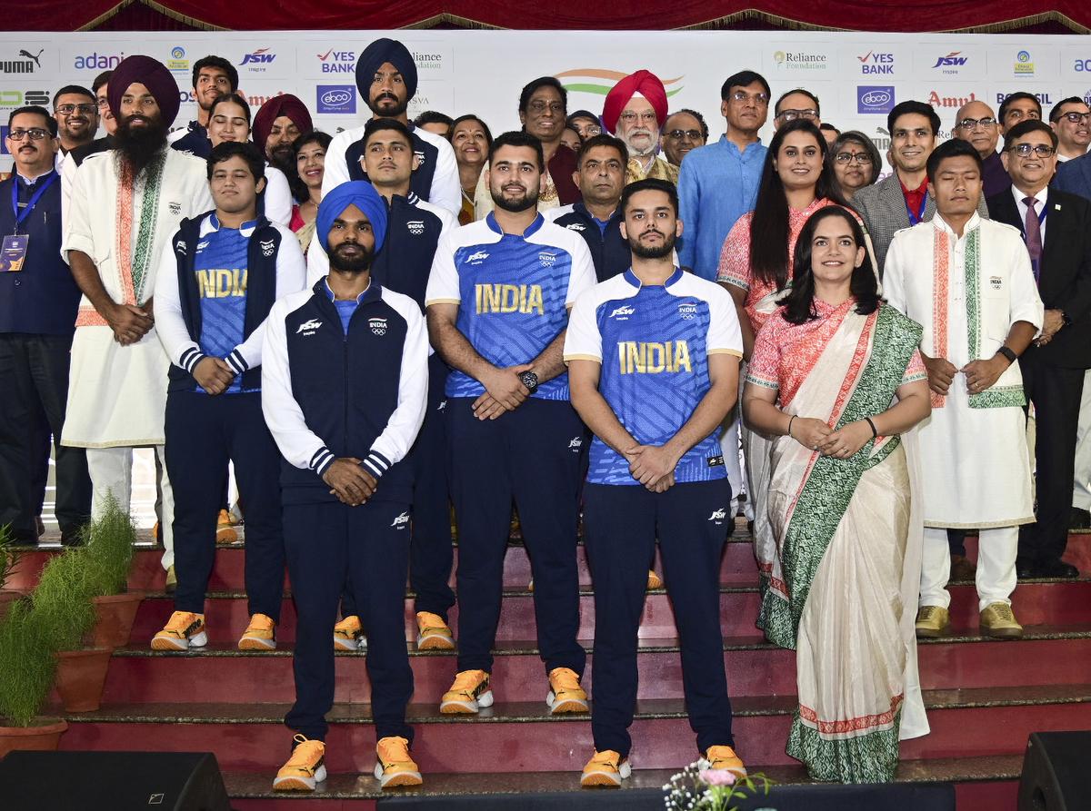 Indian athletes posing with officials as they model India’s ceremonial and playing uniforms for the Paris Olympics.