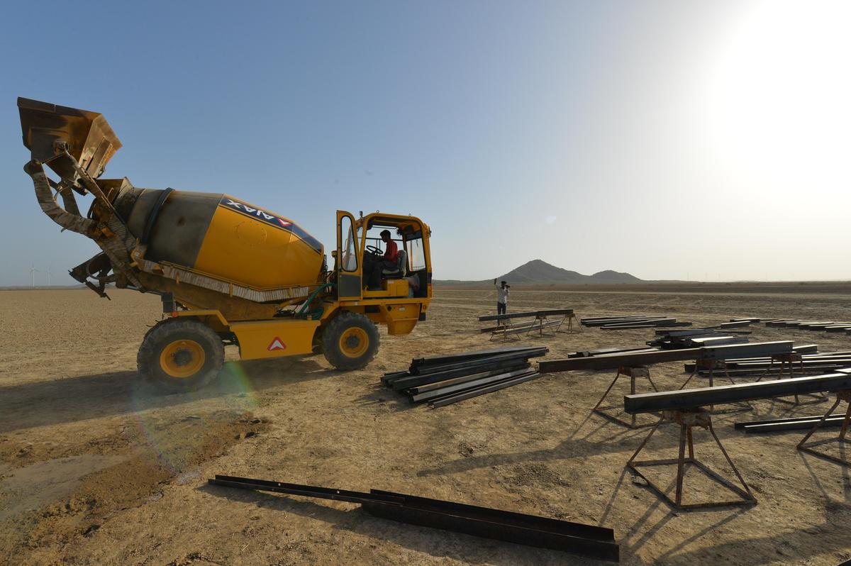 Workers start their solar project work for NTPC near the Kiro hill in middle of the Chhari Dhand wetland, in Gujarat.