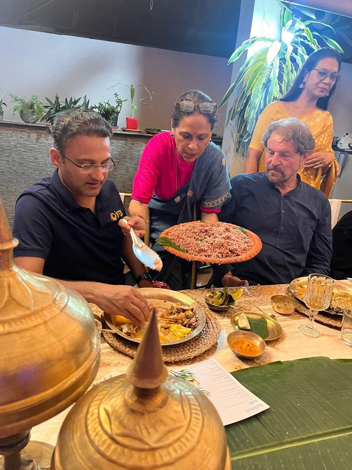 Guests being served Assamese food by Kashmiri at her home 