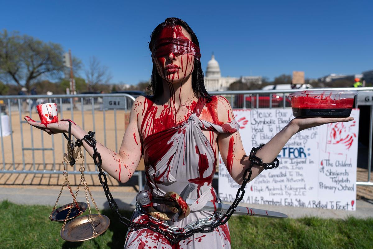 A demonstrator covered in fake blood attends a rally on the National Mall during a 'No Kings' protest in Washington, on Saturday, March 28, 2026.
