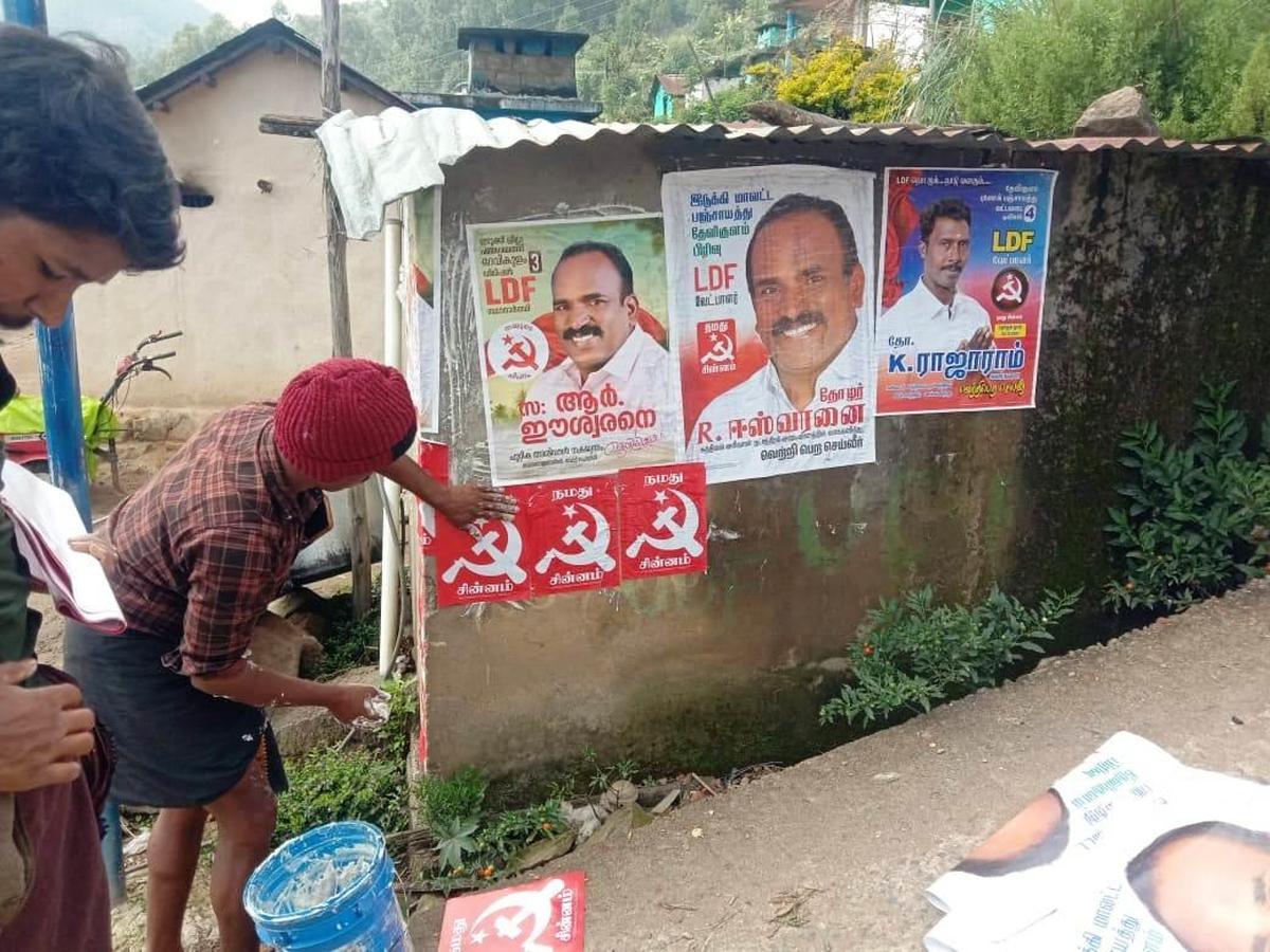 Trabalhadores do partido fixando cartazes em Tamil em Vattavada em Idukki. 
