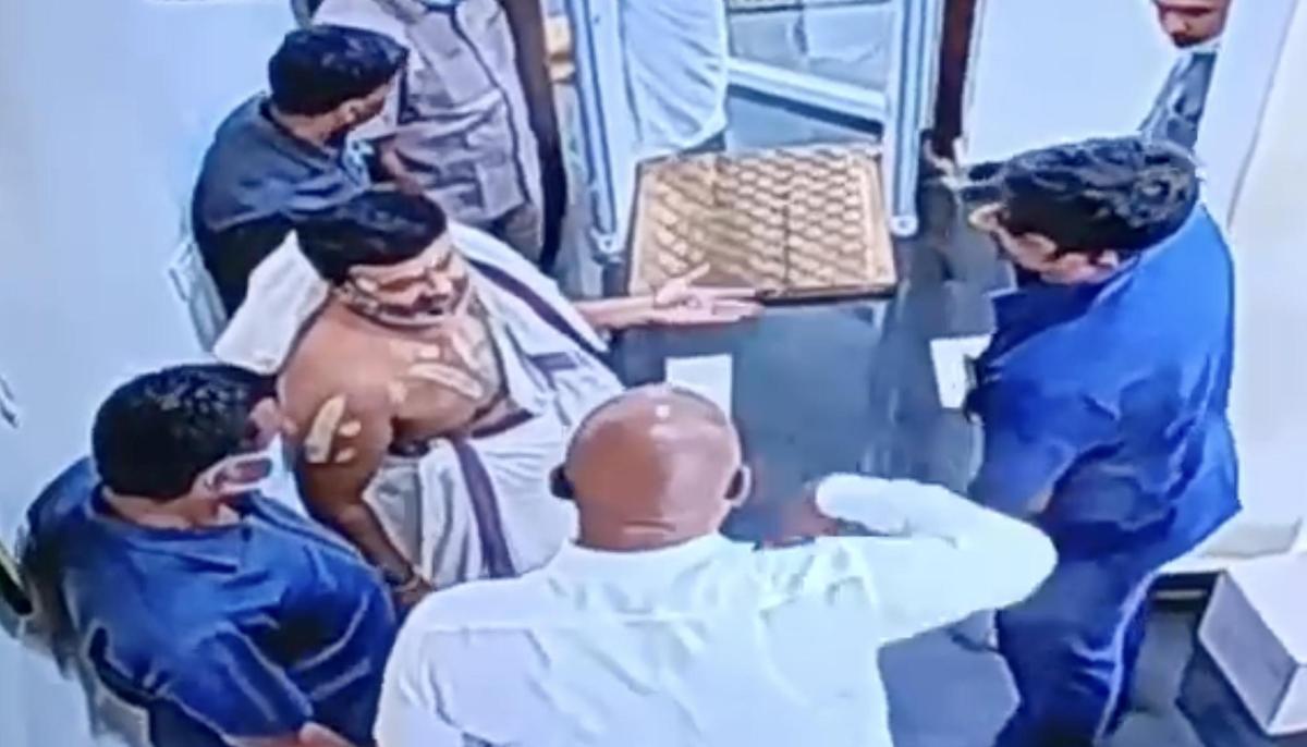 A screengrab from TTD’s CCTV network shows vigilance officials speaking to Parakamani scam accused C.V. Ravi Kumar before frisking him on the day of the incident.