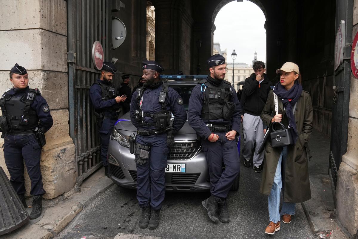 Police officers block an access to the Louvre museum after a robbery in Paris on October 19, 2025.