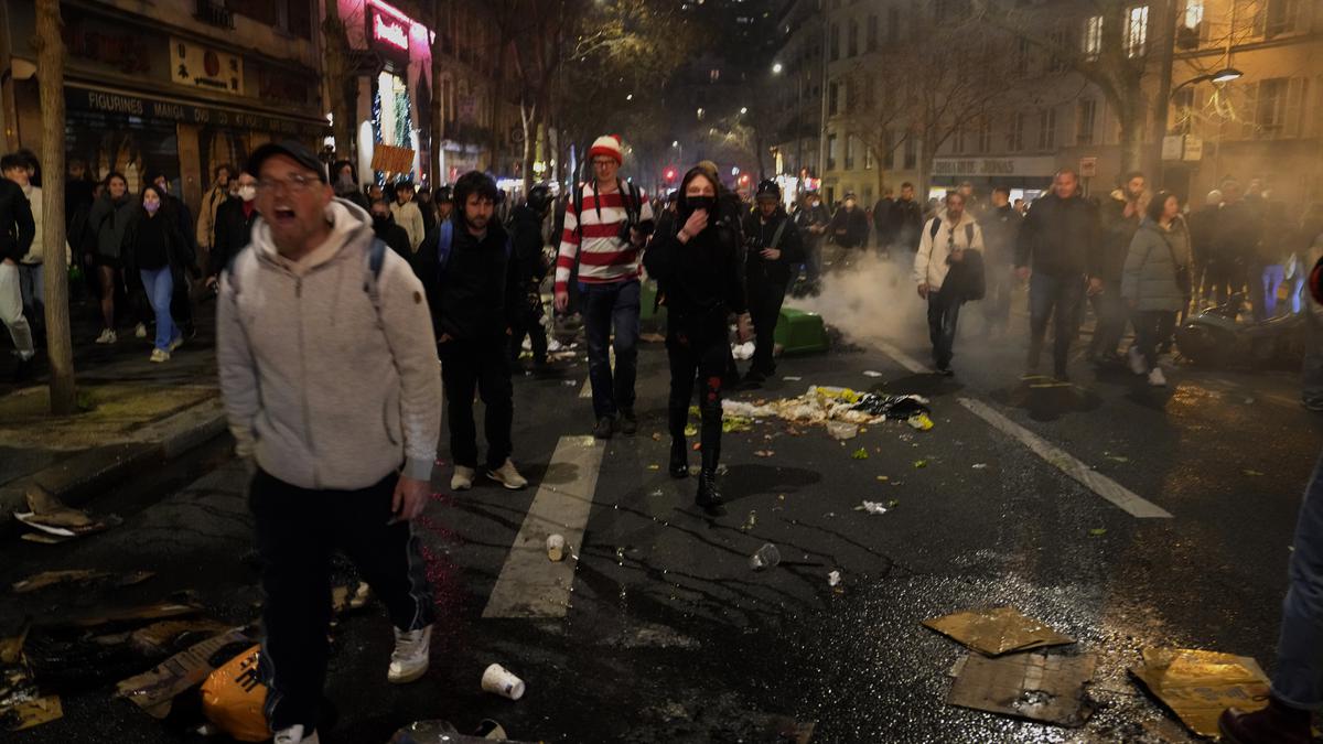 French protesters march past garbage piles, resisting Macron