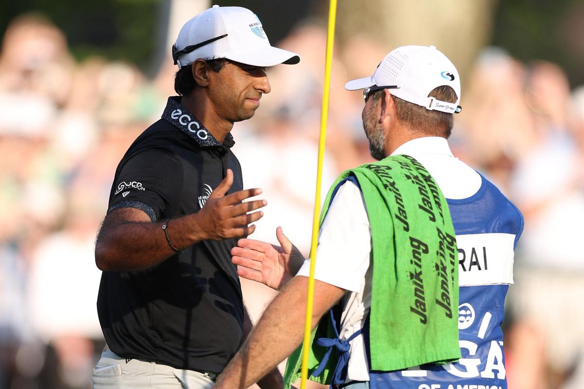 Aaron Rai of England and caddie Jason Timmis shake hands on the 18th green during the final round of the PGA Championship