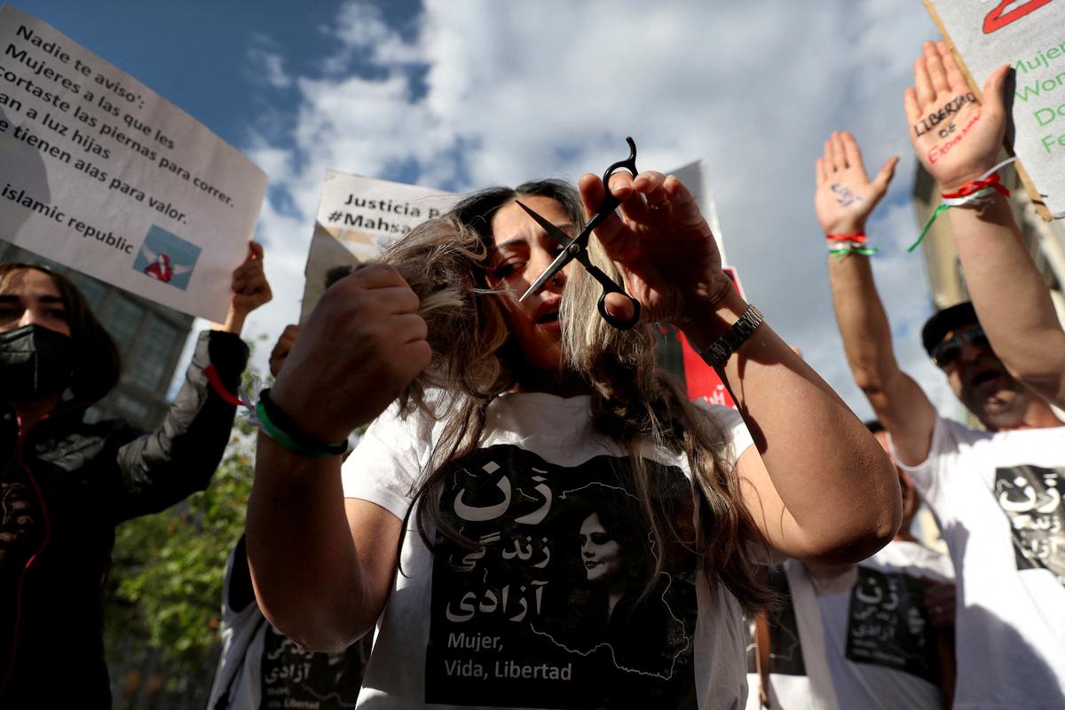 A woman cuts her hair in solidarity with Iranian women, in Santiago, Chile, October 7, 2022. 