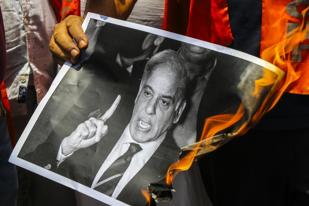 Activists burn a poster of Pakistan Prime Minister Shehbaz Sharif in protest against the recent terrorist attacks, in Jammu.