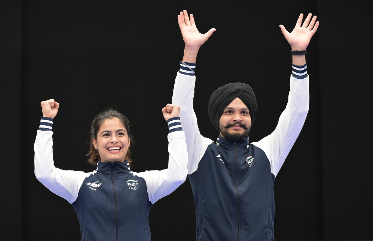 Sarabjot Singh and Manu Bhaker celebrate after winning bronze medal in the 10m air pistol mix doubles team event at the Paris 2024 Olympics.