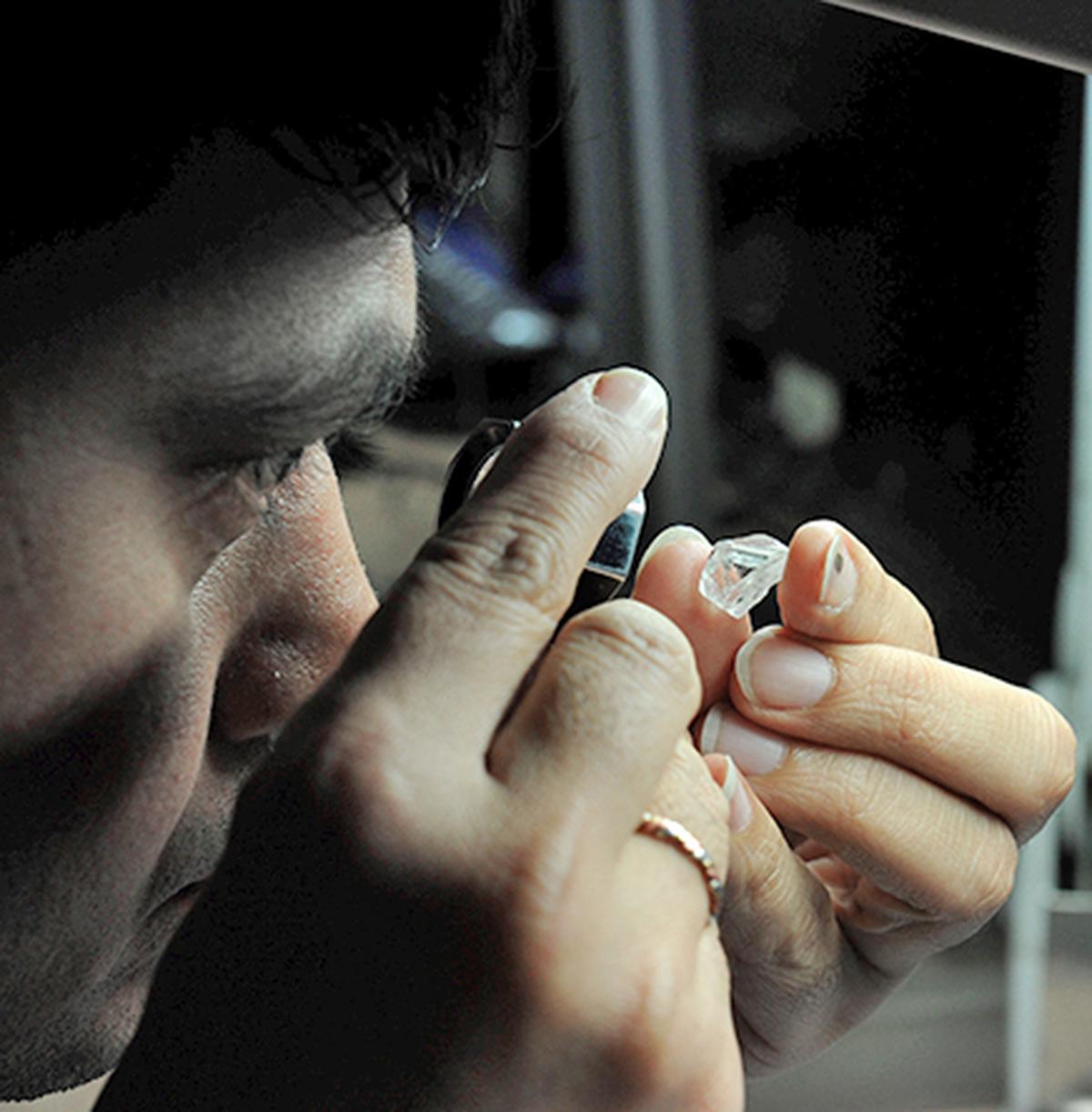 A worker in one of the oldest and largest diamond polishing units of Surat checking its dazzle. A worker in one of the oldest and largest diamond polishing units of Surat checking its dazzle.