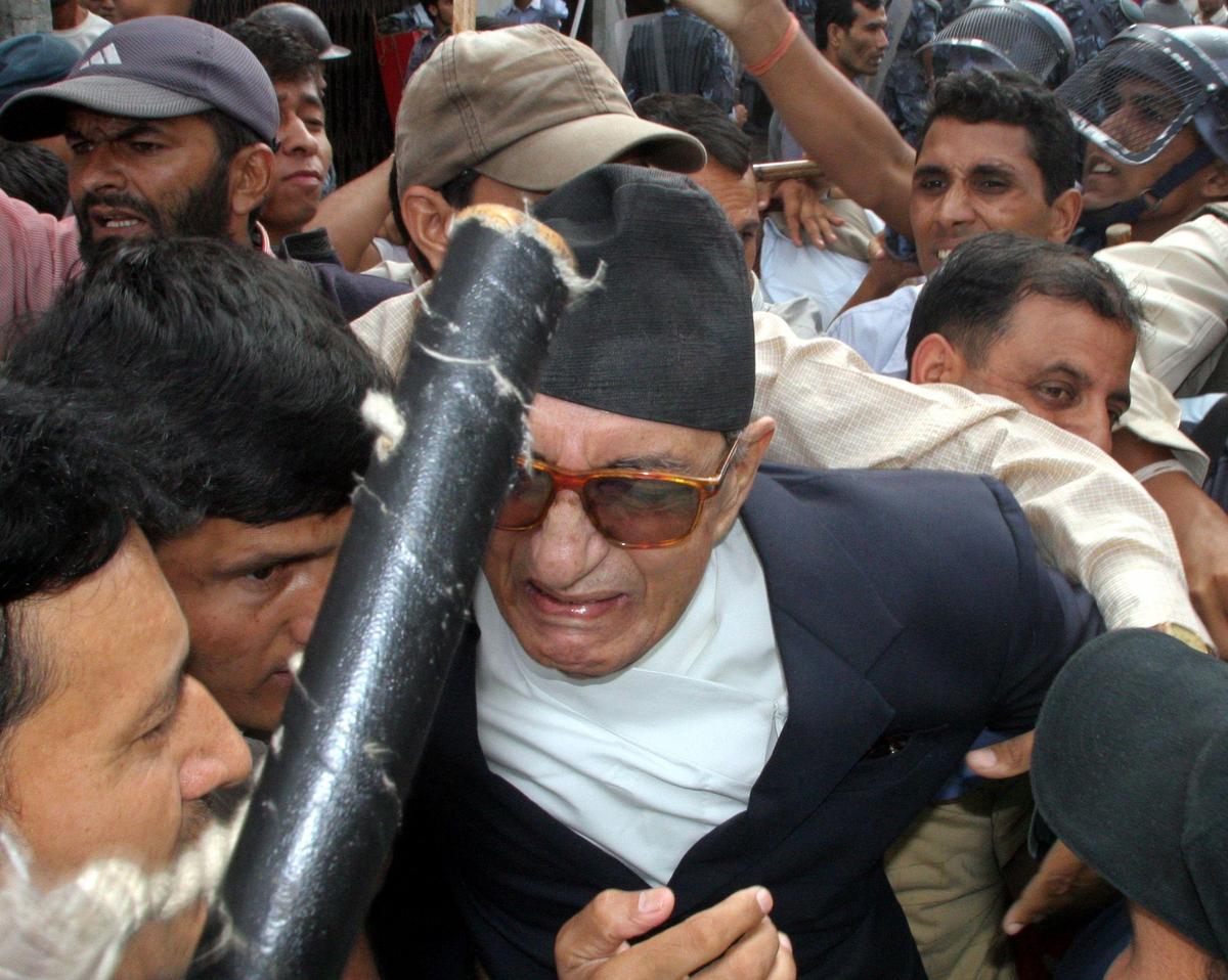 Nepali Congress leader and former prime minister Girija Prasad Koirala (C) tussles with Nepali police while trying to break into a restricted area at New Road in the capital Kathmandu September 4, 2005. Members and supporters of major political parties took part in a protest demanding the re-establishment democracy.