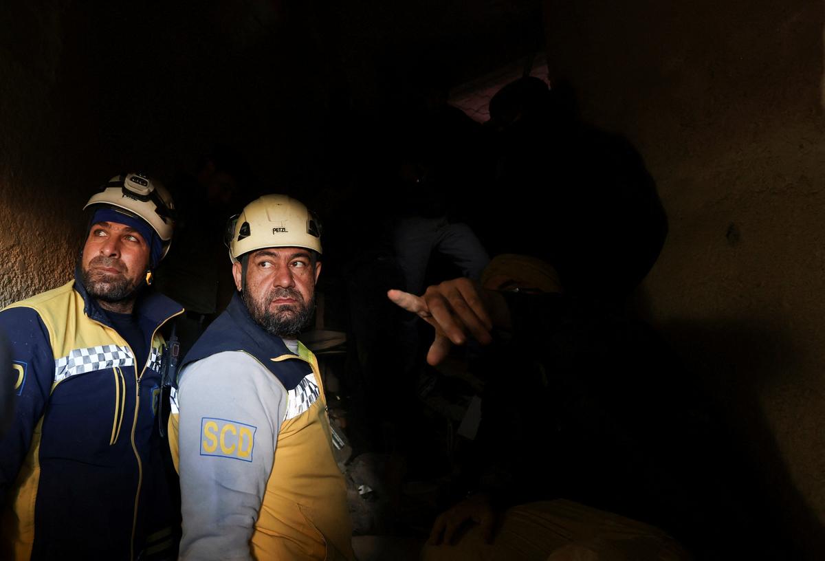 Members of the Syrian civil defence group, known as the White Helmets, search for prisoners underground at Sednaya prison, with rebel fighters around, in Sednaya, Syria on December 9, 2024. 