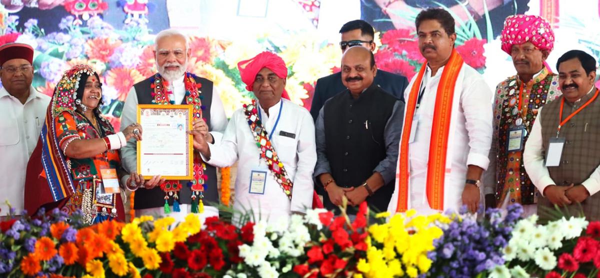 Lambani woman who received a land rights certificate for her house from Prime Minister Narendra Modi at a massive public meeting at Malkhed in Kalaburagi district on Thursday.  Also seen Governor Tawarchand Gehlot , Chief Miister Basavaraj Bommai , Minister of Revenue R Ashok and Minister of Animal Husbandary Prabhu Chavan in the picture.