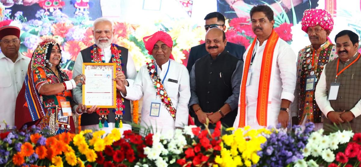 Lambani woman, who received the land title certificate for her house from Prime Minister Narendra Modi at a huge public meeting at Malkhed in Kalaburagi district.  Also seen in the picture are Governor Tavarchand Gehlot, Chief Minister Basavaraj Bommai, Revenue Minister R Ashok and Animal Husbandry Minister Prabhu Chavan.