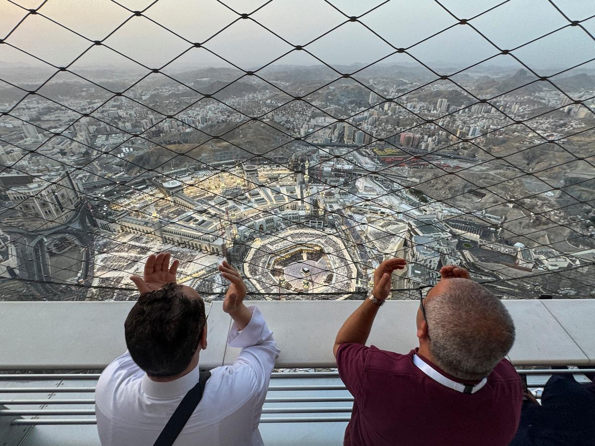 People pray at the Clock Towers with the view of the Grand Mosque, ahead of the annual haj pilgrimage, in Mecca, Saudi Arabia, on June 11, 2024. 