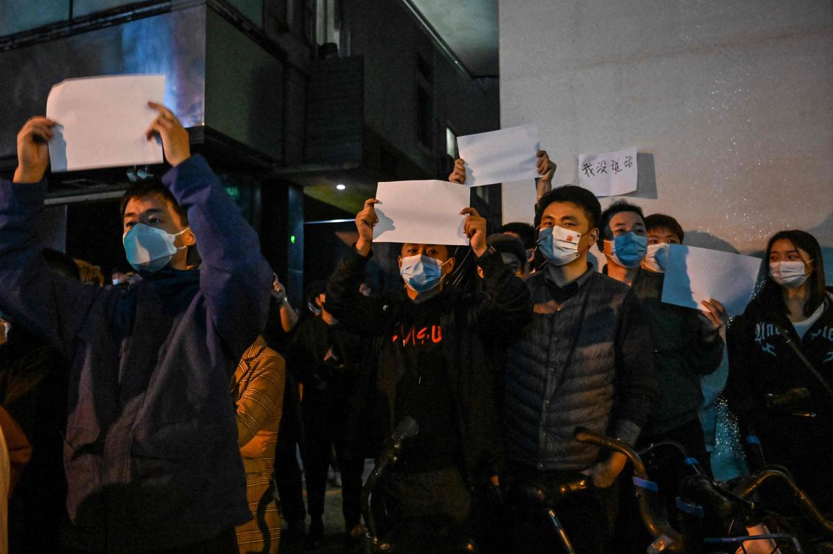 People show blank papers as a way to protest, is seen on a wall while gathering on a street in Shanghai on November 27, 2022, where protests against China’s zero-Covid policy took place the night before. Text in the sheet in the background reads: “I didn’t say anything”