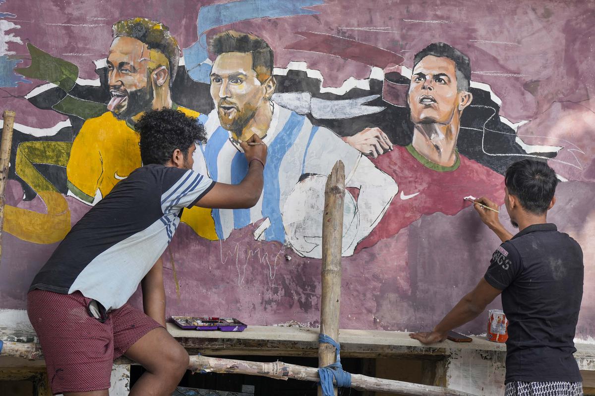 Fans create a mural featuring football stars Neymar Jr., Lionel Messi, and Cristiano Ronaldo, ahead of the FIFA World Cup Qatar 2022, in Kolkata.