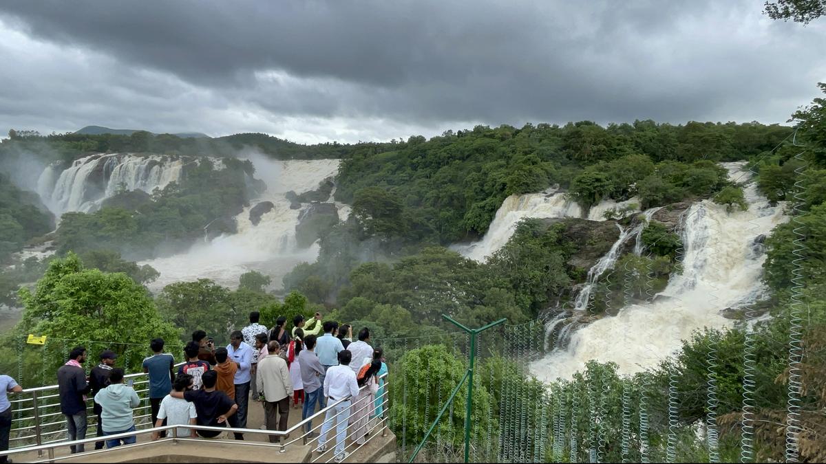 Tourists from Bengaluru watch river Cauvery at Bharachukki falls in south Karnataka