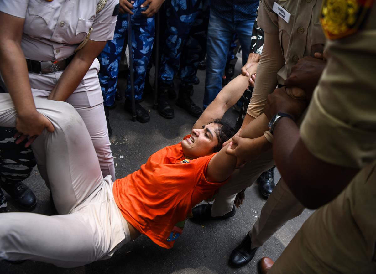 Police personnel detained wrestler Sangeeta Phogat during a protest march from Jantar Mantar to the New Parliament building against alleged sexual harassment of women wrestlers by WFI leader Brij Bhushan Sharan Singh , in New Delhi on Sunday.  (Photo by ANI/Amit Sharma)