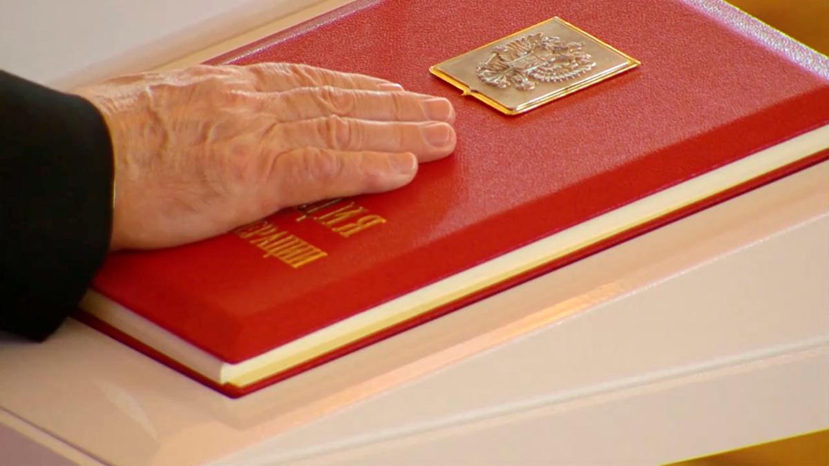 Russian President Vladimir Putin places his hand on the Constitution as he takes the oath during an inauguration ceremony at the Kremlin in Moscow, Russia May 7, 2024, in this still image taken from live broadcast video. 