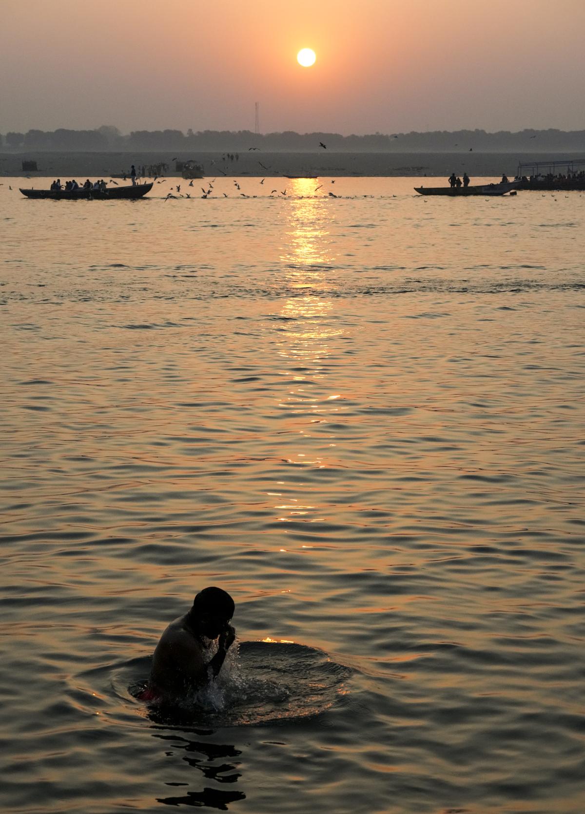 A devotee takes a holy dip in the Ganga river during sunrise, in Varanasi. A devotee takes a holy dip in the Ganga river during sunrise, in Varanasi.