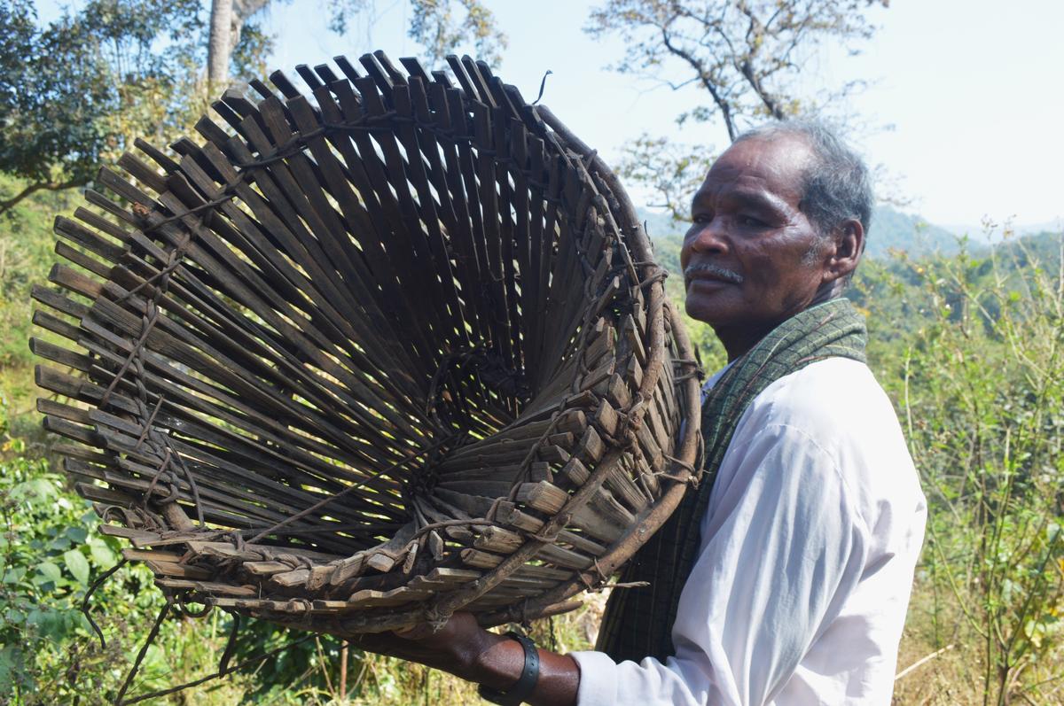 Konda Reddi tribal elder Pallala Boddu Reddi shows a fishing basket he crafted with bamboo at Aaku Maamidi Kota.