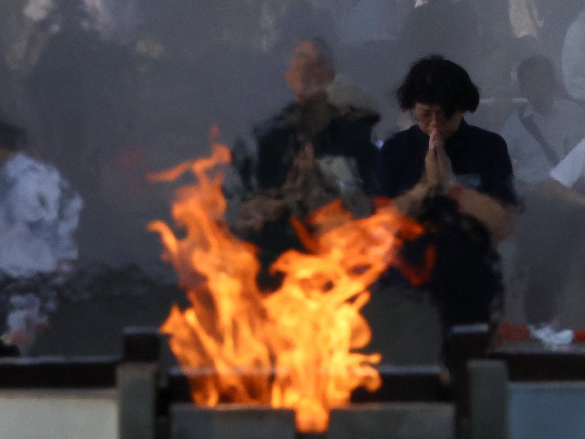 People pray in front of the cenotaph for the victims of the 1945 atomic bombing, at the Peace Memorial Park in Hiroshima on the 80th Atomic Bombing Day anniversary in Hiroshima, western Japan, August 6, 2025. 