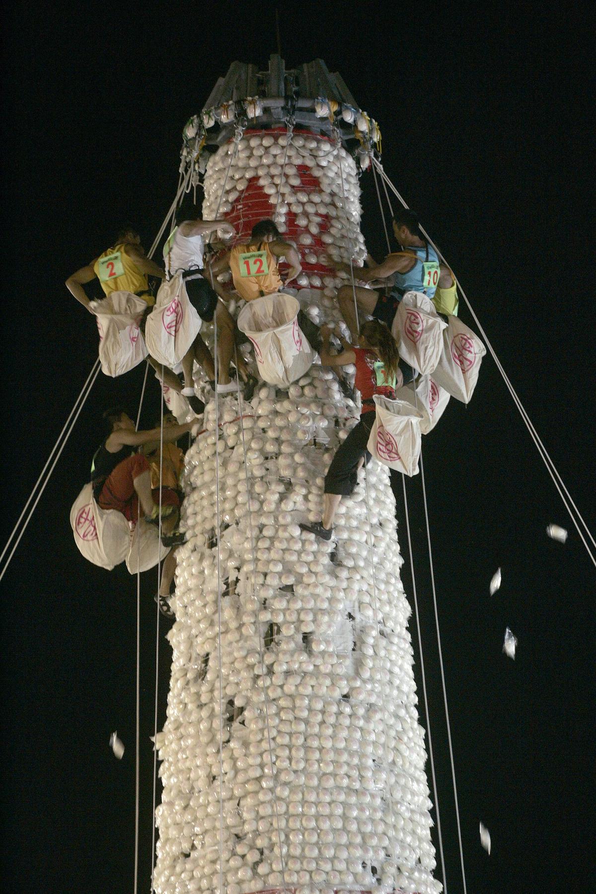 Climbers collect mock buns on a tower during a ‘bun-scrambling’ event as part of the Bun Festival on the island of Cheung Chau in Hong Kong at midnight. The Bun Festival, a traditional ritual on the island, is a combination of combination of praying to gods and driving away plague and evil spirits.   