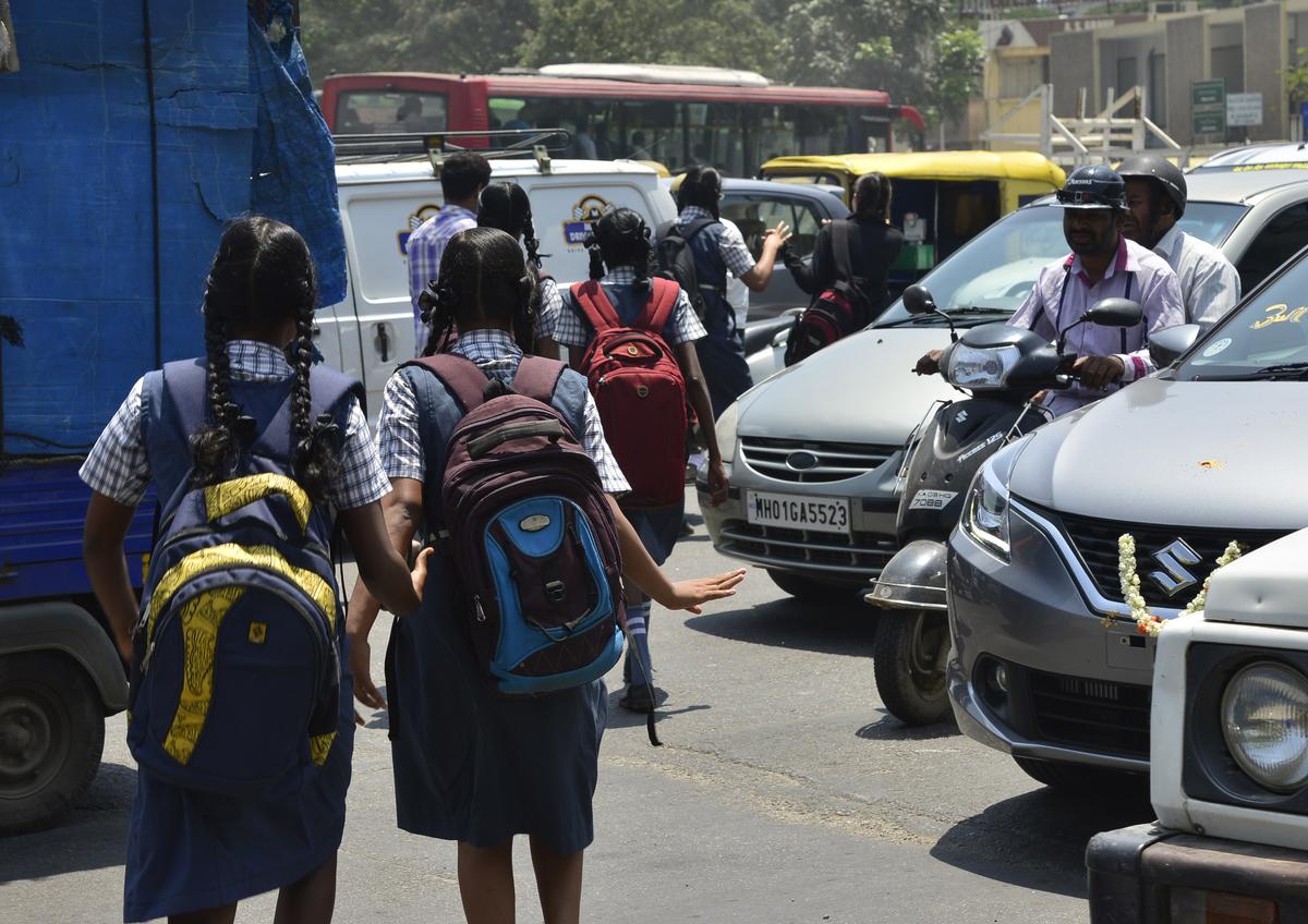 A file photo of schoolchildren crossing a road in Bengaluru. People living around schools that have come up in residential areas have complained about traffic jams during morning and evening hours. A file photo of schoolchildren crossing a road in Bengaluru. People living around schools that have come up in residential areas have complained about traffic jams during morning and evening hours.