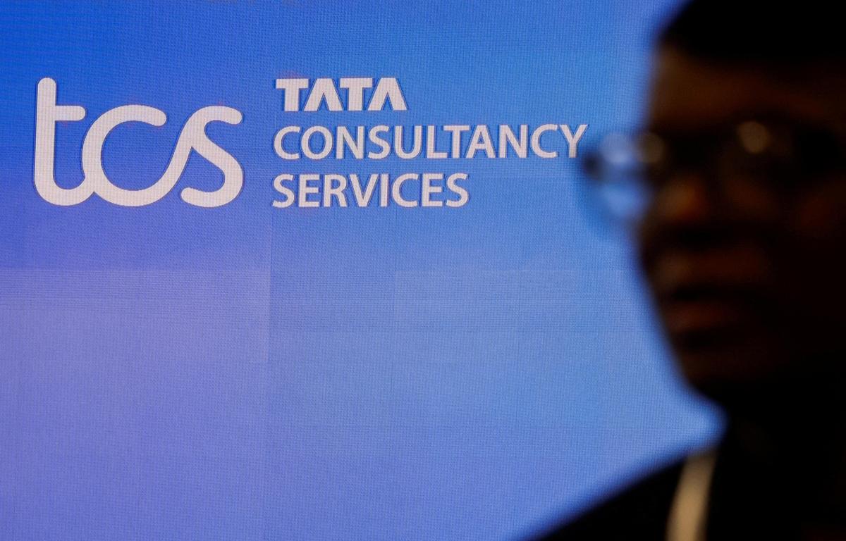 A man walks past a logo of Tata Consultancy Services (TCS). (FILE)