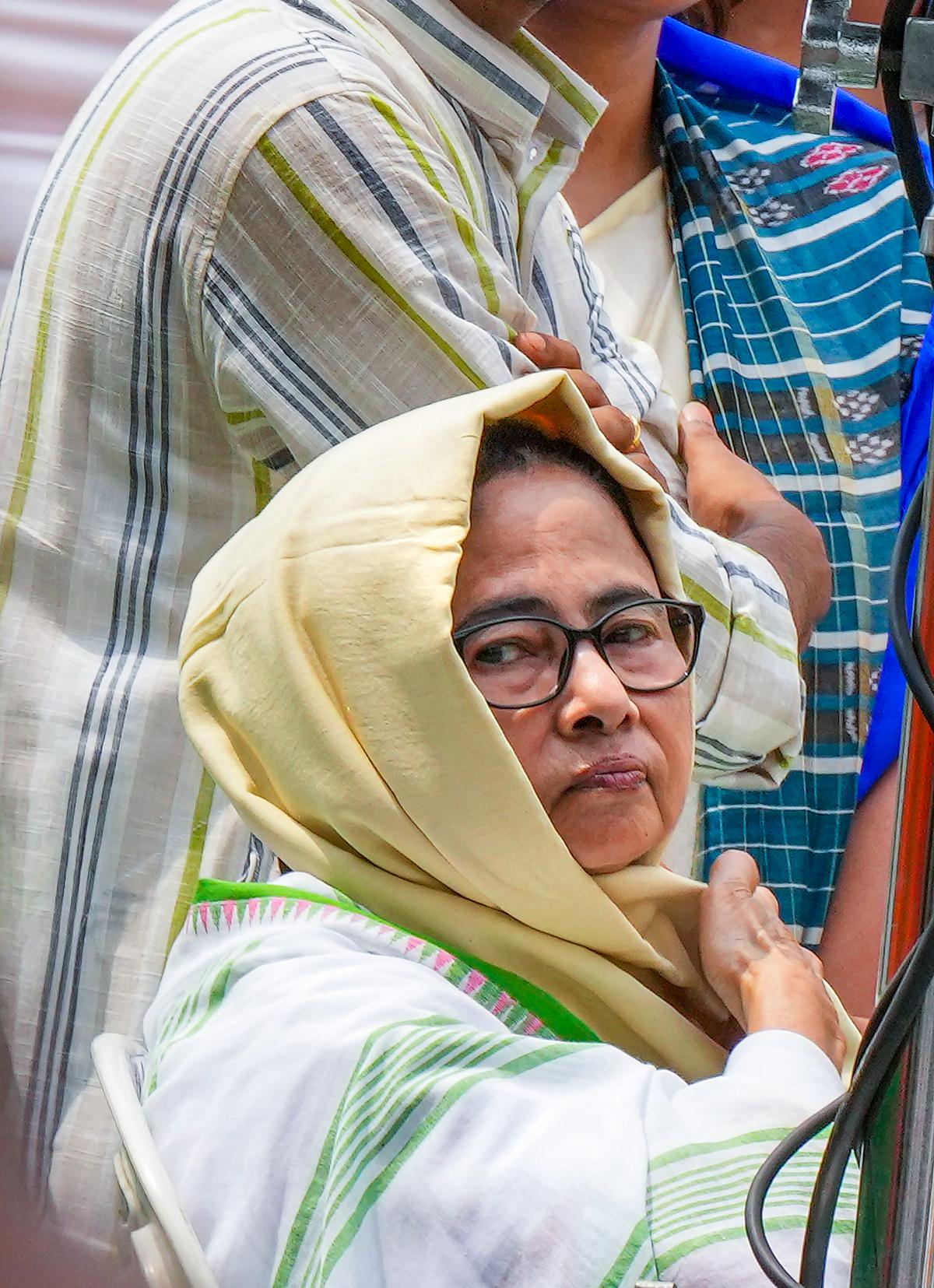 West Bengal Chief Minister Mamata Banerjee uses a scarf to protect herself from the heat during the foundation day celebrations of Trinamool Congress Chhatra Parishad, in Kolkata.
