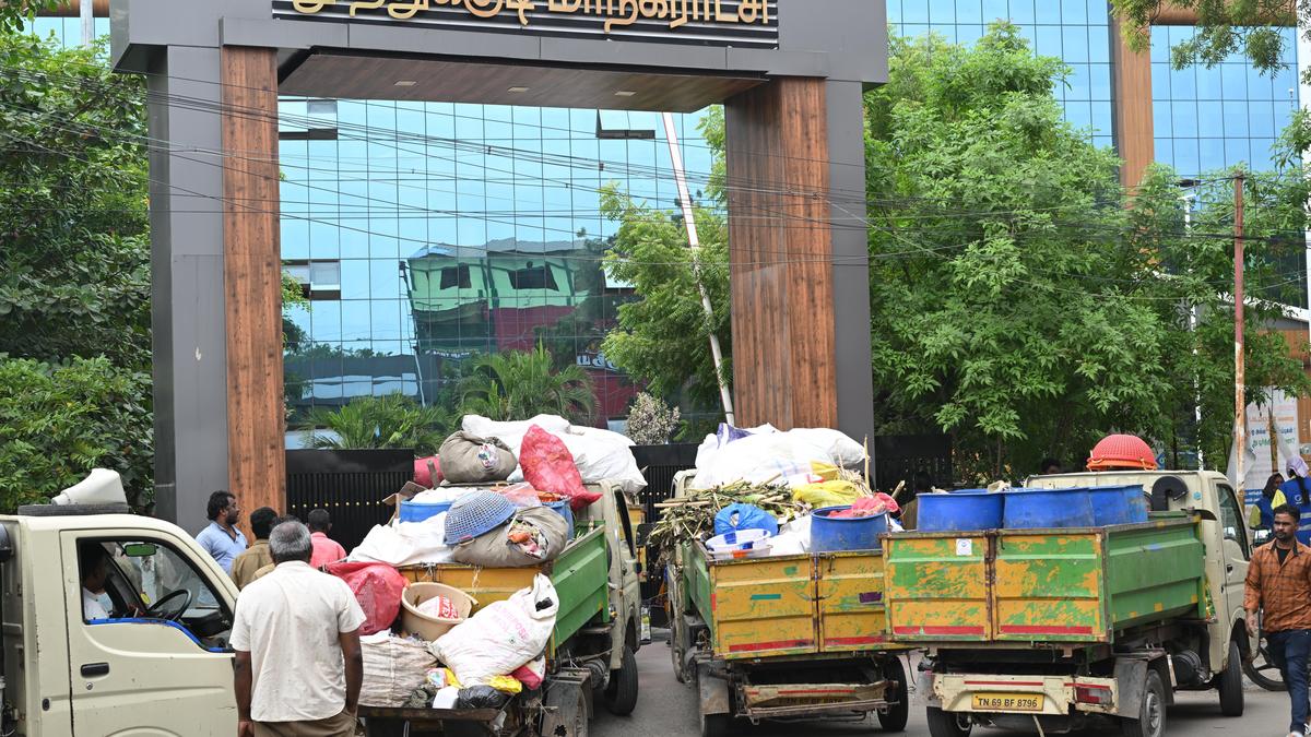 Sanitary workers line-up garbage-laden vehicles at Corporation demanding revoking of suspension of their leader